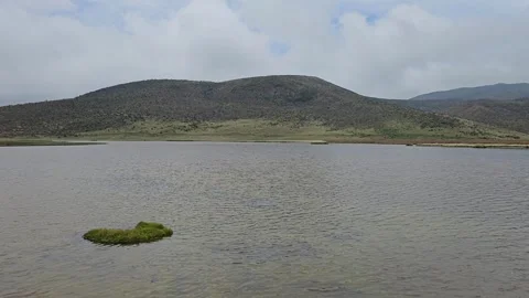 Lagoon with Tiny Grass Island and Distant Peaks, Laguna Limpiopungo, Ecuador 8K Stock Footage 331497684