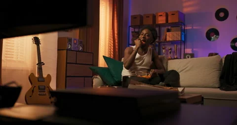 A laid-back guy relaxes on the couch in the living room, a man with an afro in a Vidéo 200810400