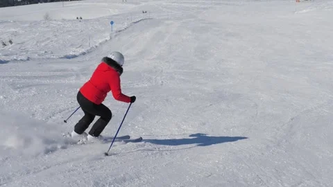 Laid back skier dressed brightly making controlled downhill runs Stock Footage 322798122