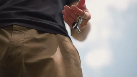 Laidback Individual In Cargo Shorts With Keys Against Bright Sky, Relaxed Person Stock Footage 327170210
