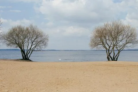 Lake and sandy beach on windy cloudy day Stock Photos