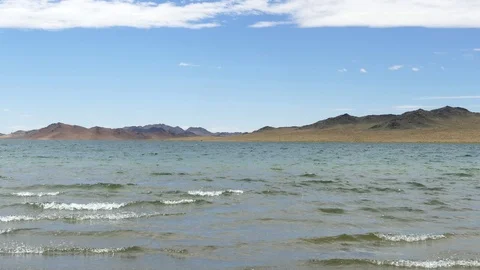 Lake and waves, mountains in the distance. Stock Footage 79776257