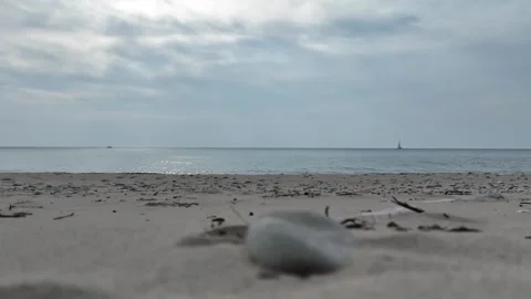 Lake Beach with Stone in Foreground and Gentle Waves Crashing on Shore Stock Footage 248929478