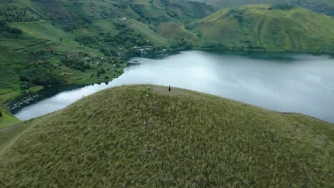 The lake behind the high hill and the meadow from above Stock Footage 213920913