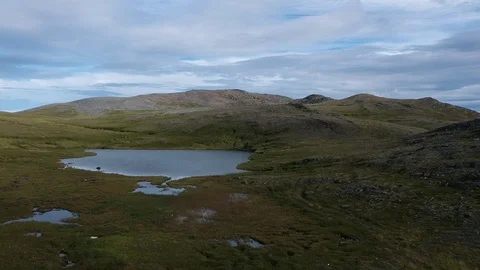 A lake between green hills. Cloudy northern landscape Stock Footage 114982608