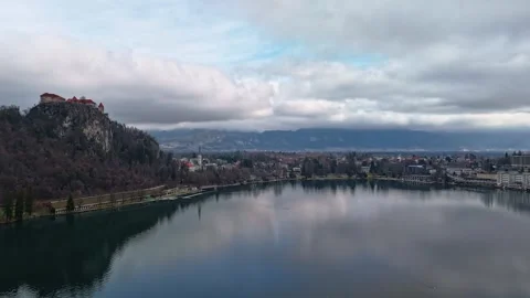 Lake Bled sits below its clifftop castle amid mountains and forested shores Stock Footage 336467601