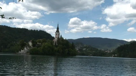 Lake with church in forest surrounding Stock Footage
