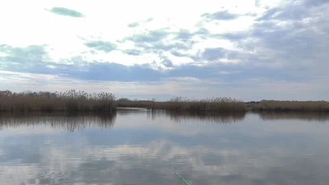 Lake with cloud reflection on calm water surface creating mirror landscape, Stock Footage 336618539