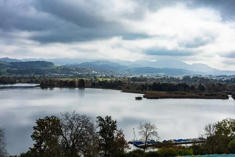 A lake with a cloudy sky in the background Stock Photos