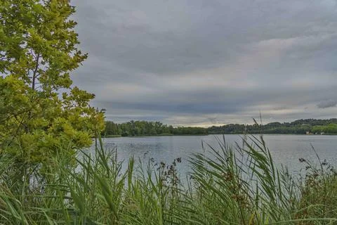 A lake with a cloudy sky in the background Stock Photos