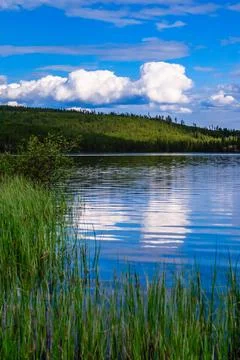 A lake with a cloudy sky in the background Stock Photos
