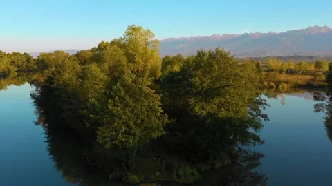 Lake at the edge of the mountains with forest reflected in the clear water Stock Footage 150600600