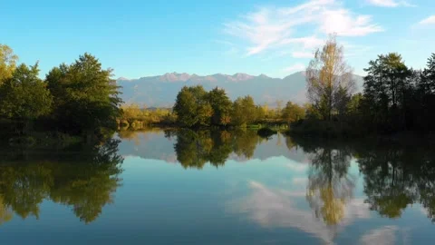 Lake at the edge of the mountains with forest reflected in the clear water Video stock 150600616