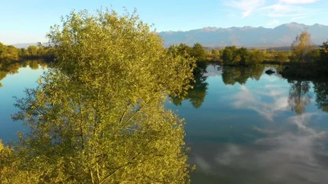 Lake at the edge of the mountains with forest reflected in the clear water Video stock 150600623
