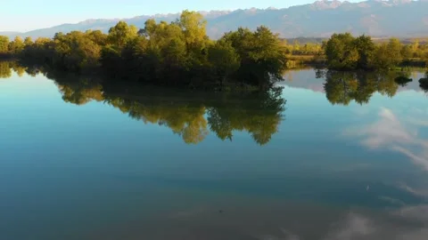 Lake at the edge of the mountains with forest reflected in the clear water Stock Footage 150609317