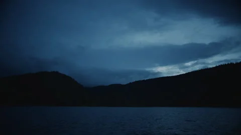 Lake in evening with tiny campfire in the distance Stock-Footage 232342518