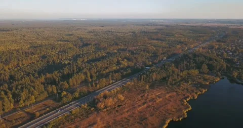 Lake, forest and highway with moving traffic from above Stock Footage 345370693