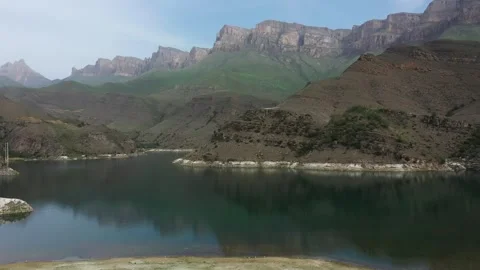 Lake Gizhgit surrounded by mountains in summer in Elbrus region, drone view Stock Footage 277404332