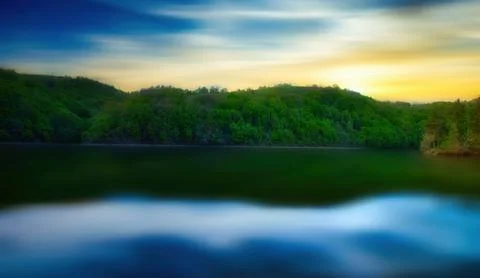 A lake with a long exposure time, with the reflection of the clouds in the .. Stock Photos