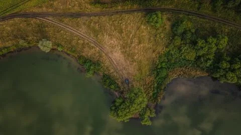 The lake in the middle of endless green fields Stock Photos