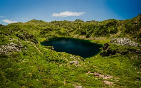 Lake in mountain range: A pristine lake mirrors the majestic mountain peaks.. Stock Photos