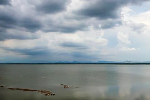 Lake with mountains in the background under the cloudy sky. Stock Photos