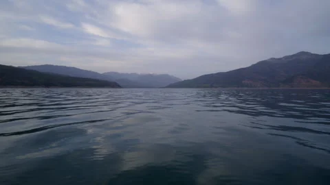 Lake in the mountains, camera at the water surface. taken from a boat in motion Stock Footage 241500664