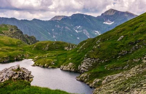 Lake in mountains with grass on hillside Stock Photos