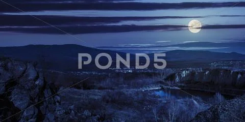 Lake in mountains quarry near city at night Stock Photos