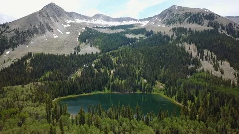 Lake nestled at base of mountain Stock Footage 86477913