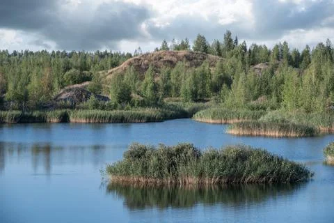 A lake with a plane surface and reflections against the blue sky and clouds. Stock Photos