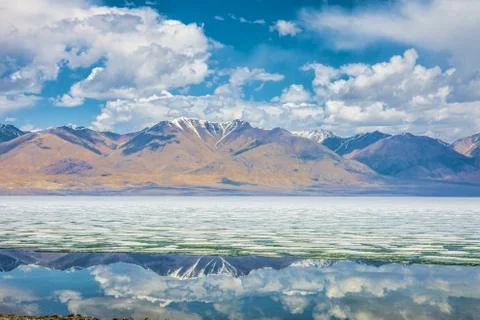 Lake with reflection of mountains and clouds on water Stock Photos