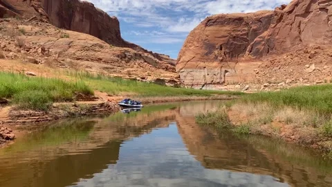 Lake reflection with red cliffs and jet skis parked 4K Stock-Footage 141888470