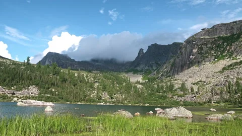 Lake Reflections: Tranquil Waters Mirrored by Majestic Peaks in Overcast Stock Footage 257363663