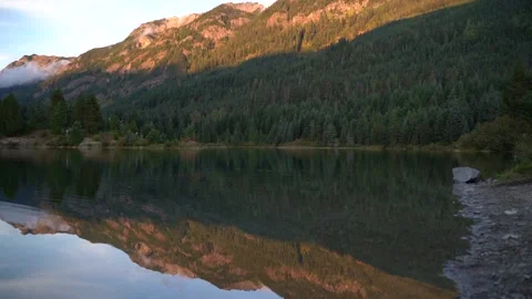 Lake with ripples mountain reflection, pan shot right to left Stock Footage 147529753