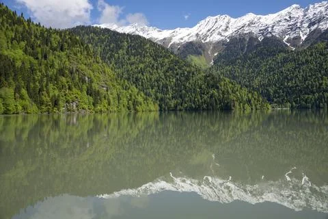 Lake Ritsa with a reflection of snow-capped mountain peaks. Abkhazia Stock Photos