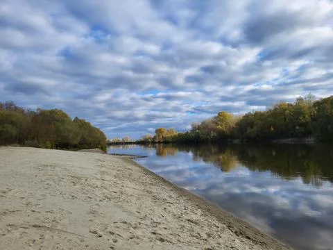 Lake with sandy beach and dramatic clouds 写真素材