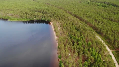 Lake with sandy beach in green forest in summer. Camping. Aerial view. Видео 140211367
