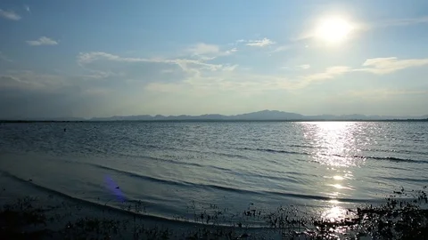 The lake like a sea have a wave and mountain blue sky fisher man in the water Stock Footage