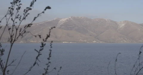 Lake Sevan Armenia Shore Foreground Branches with Distant Mountains 4K Stock Footage 326638284