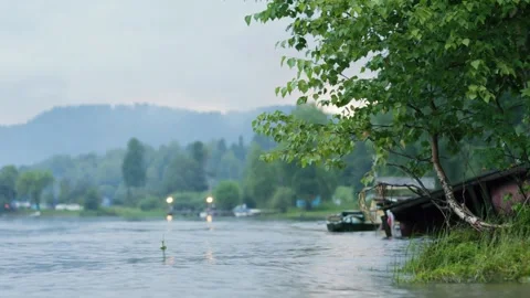 Lake shore at twilight. The sky is in the clouds, the mountains are in the Stock Footage 277532041
