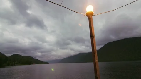 Lake shore at twilight. The sky is in the clouds, the mountains are in the Stock-Footage 277532732