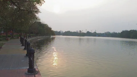 Lake side public park in summer evening. Garden footpath park lane illuminate Stock Footage 127555452