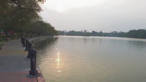 Lake side public park in summer evening. Garden footpath park lane illuminate Stock Footage 127555485
