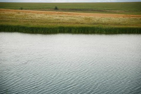 A lake in a steep valley, on a cloudy, spring day. wallpaper landscape Stock Photos