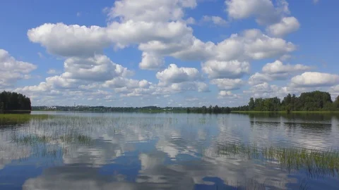 Lake on a summer day with clouds reflected in the water Video stock 83610696