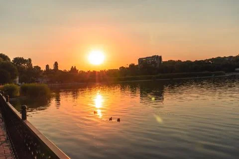 A lake with the sunset in the background, casting a warm glow Stock Photos