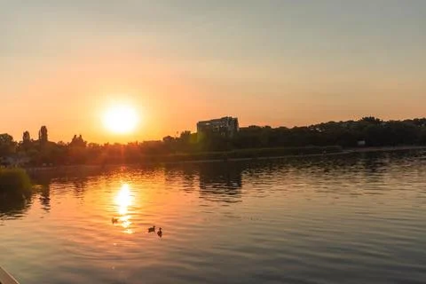 A lake with the sunset in the background, casting a warm glow Foto stock