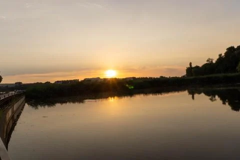 A lake with the sunset in the background, casting a warm glow Stock Photos