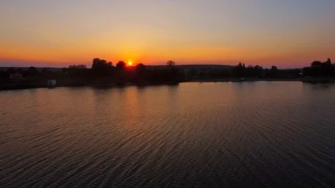 Lake at Sunset Beautiful Reflections Waves Drone Flying Over Stock Footage 128312929